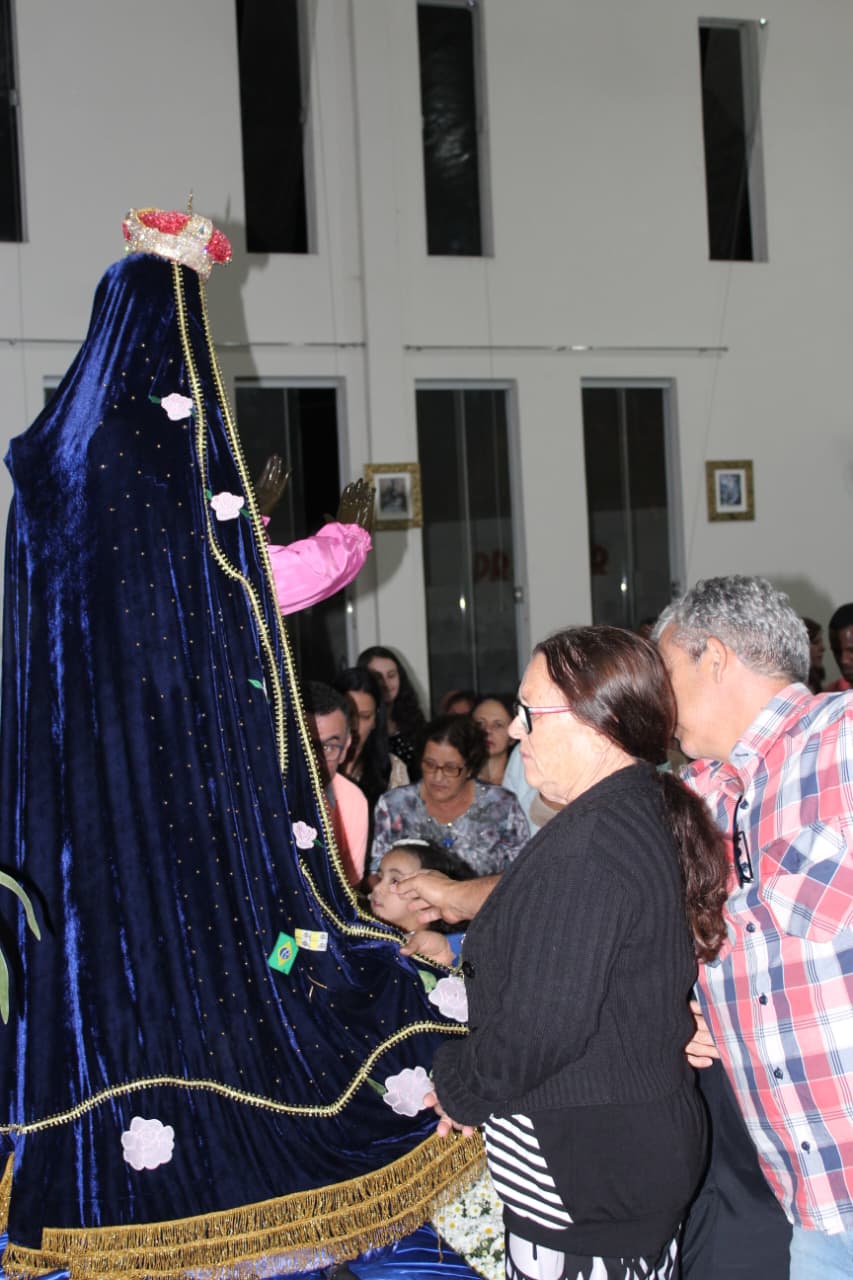 Fiéis tocando o manto azul da imagem de Nossa Senhora Aparecida